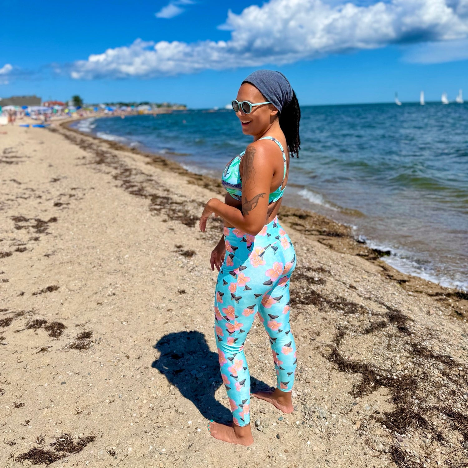 Shark tooth paradise print rashguard and dive leggings with bull shark and orange/pink plumeria flowers on a teal background