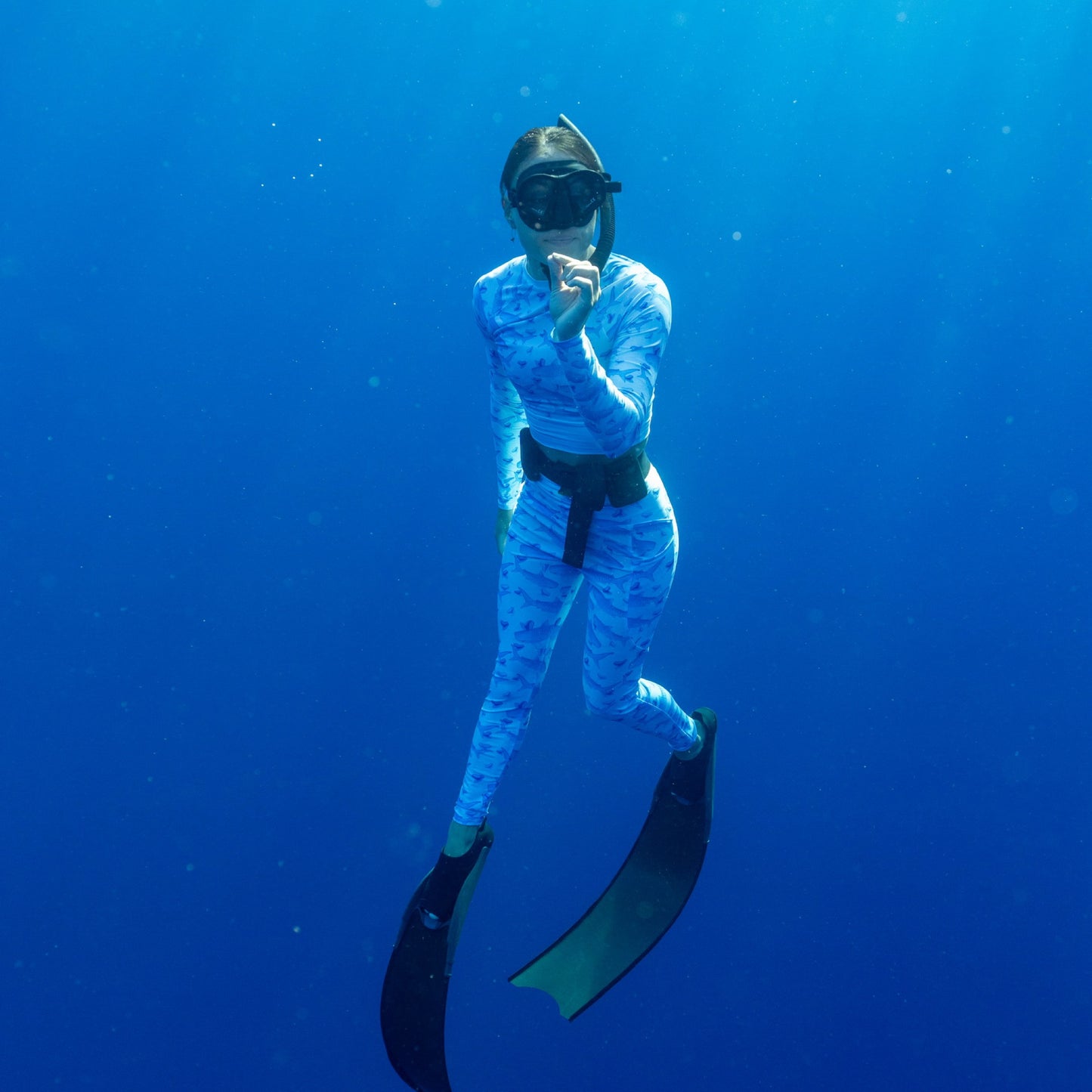 Baby blue waves and Sky Blue Tiger sharks swim around royal blue tiger shark teeth on our Tiger Beach Blues Recycled dive leggings with pockets