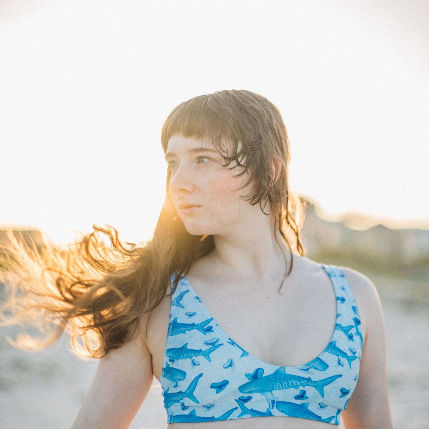 Baby blue waves and Sky Blue Tiger sharks swim around royal blue tiger shark teeth on our Tiger Beach Blues Recycled high waisted bikini
