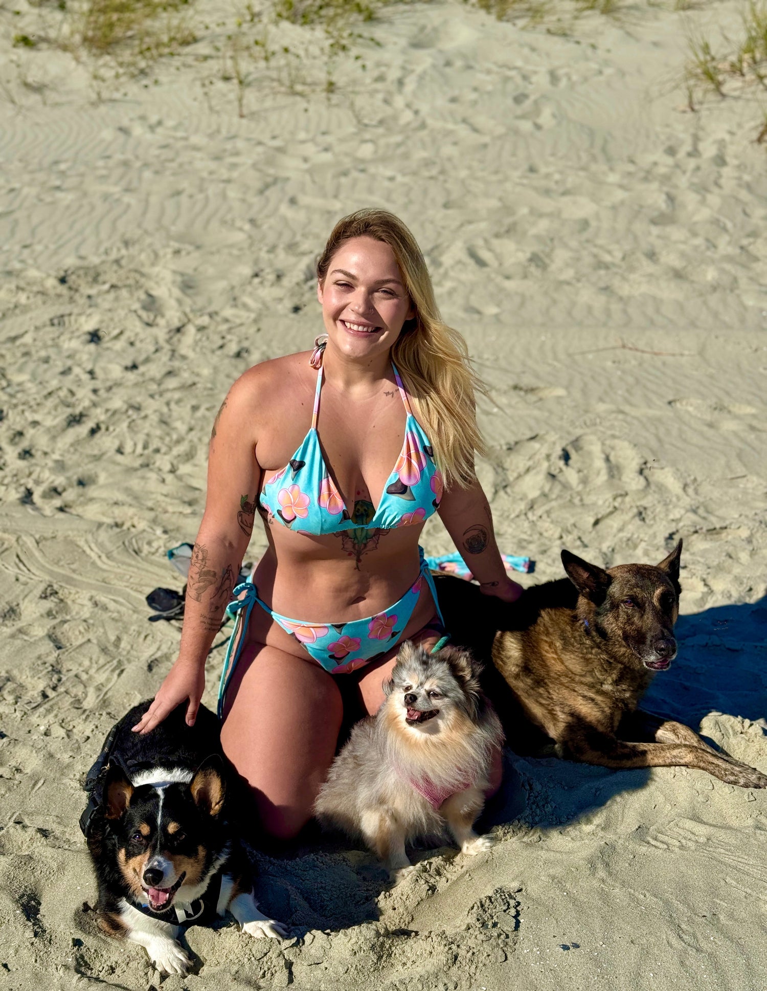 Founder of Shark fin swim with her dogs on the beach in a shark fin swim bikini