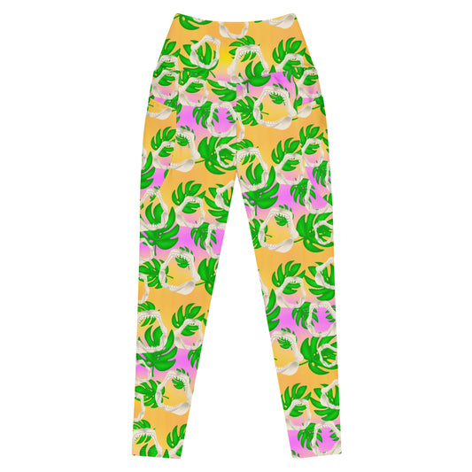 A warm golden yellow and pinky lilac sunset ombré background with megalodon jaws and monstera leaves on our Meg Monstera Recycled dive leggings with pockets