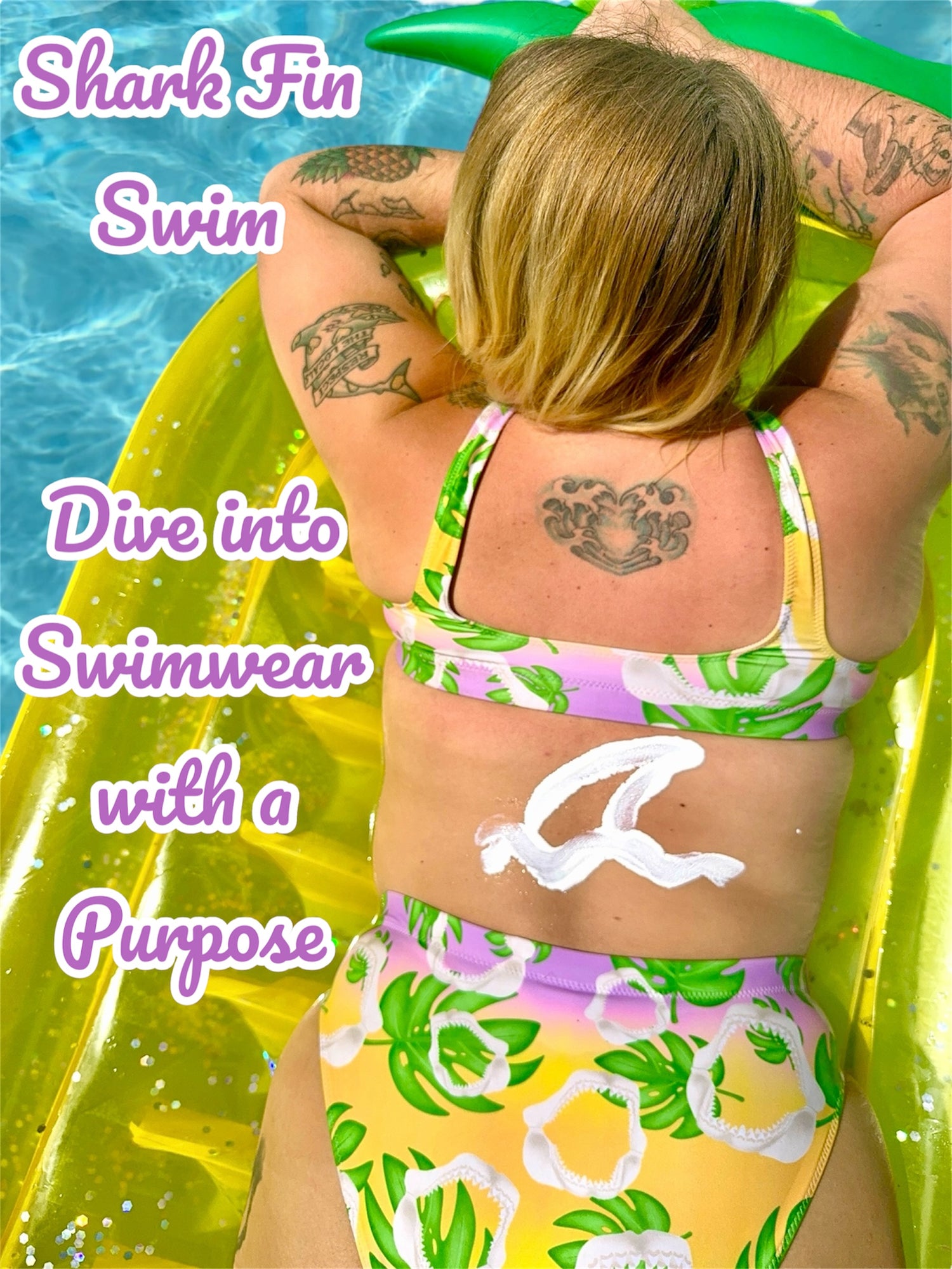Shark fin swim Meg monstera print with a sunscreen shark fin on the woman wearing the bikini’s back