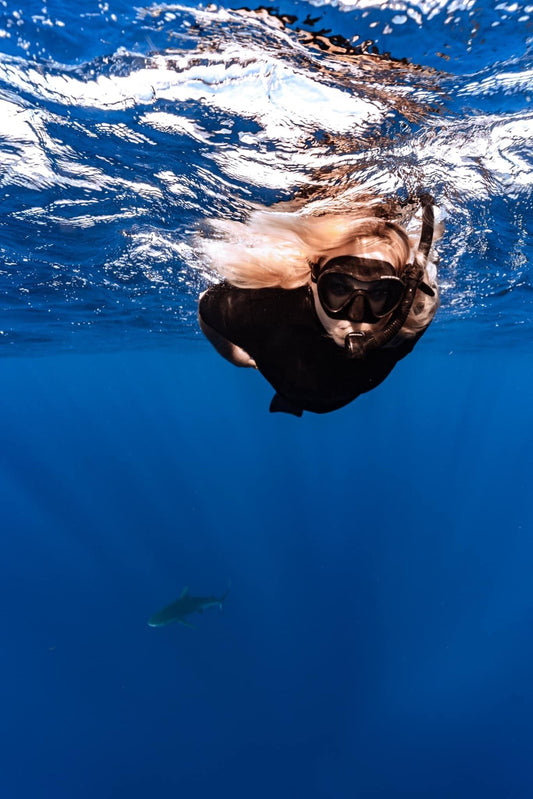 Owner of shark fin swim sustainable swimwear swimming with Galapagos sharks in Oahu Hawaii with go adventure Hawaii 