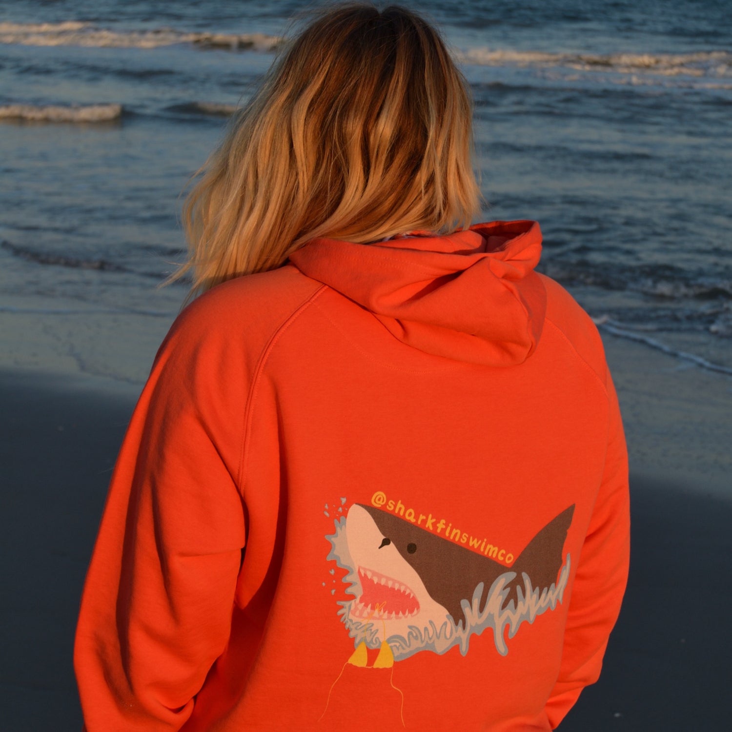 Eco-friendly hoodie with a great white shark and bikini coming out of the ocean 
