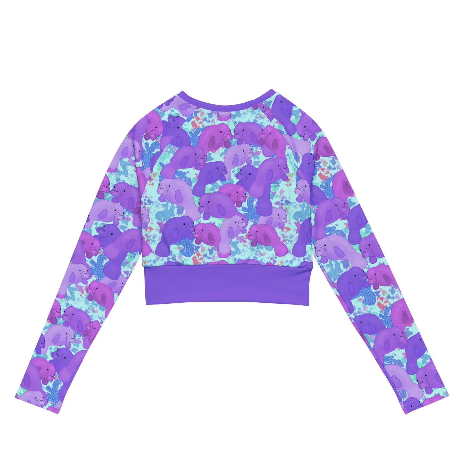 Purple manatees on a blue background of a cropped sustainable rashguard 
