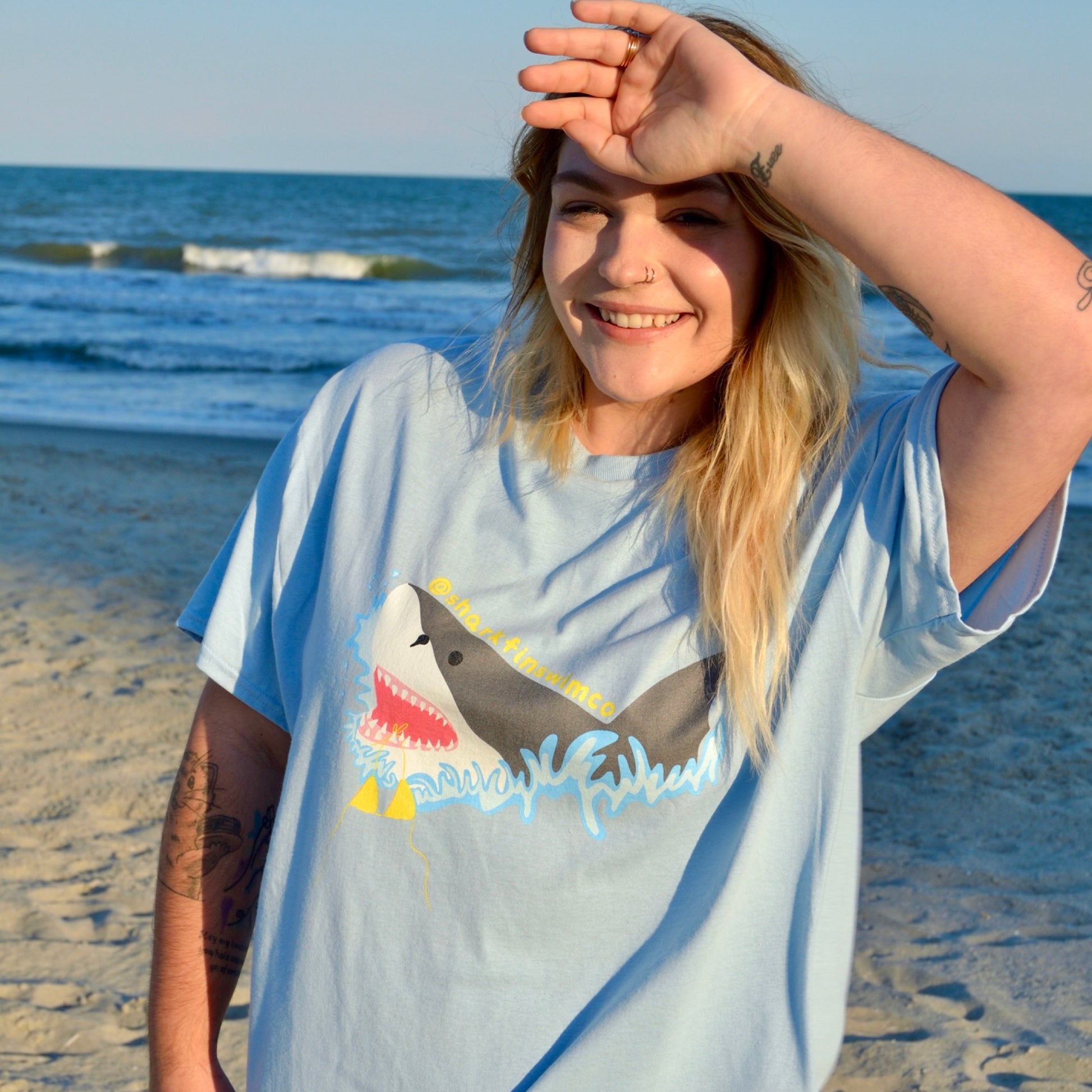 Eco-friendly t shirt with a great white shark and bikini coming out of the ocean 