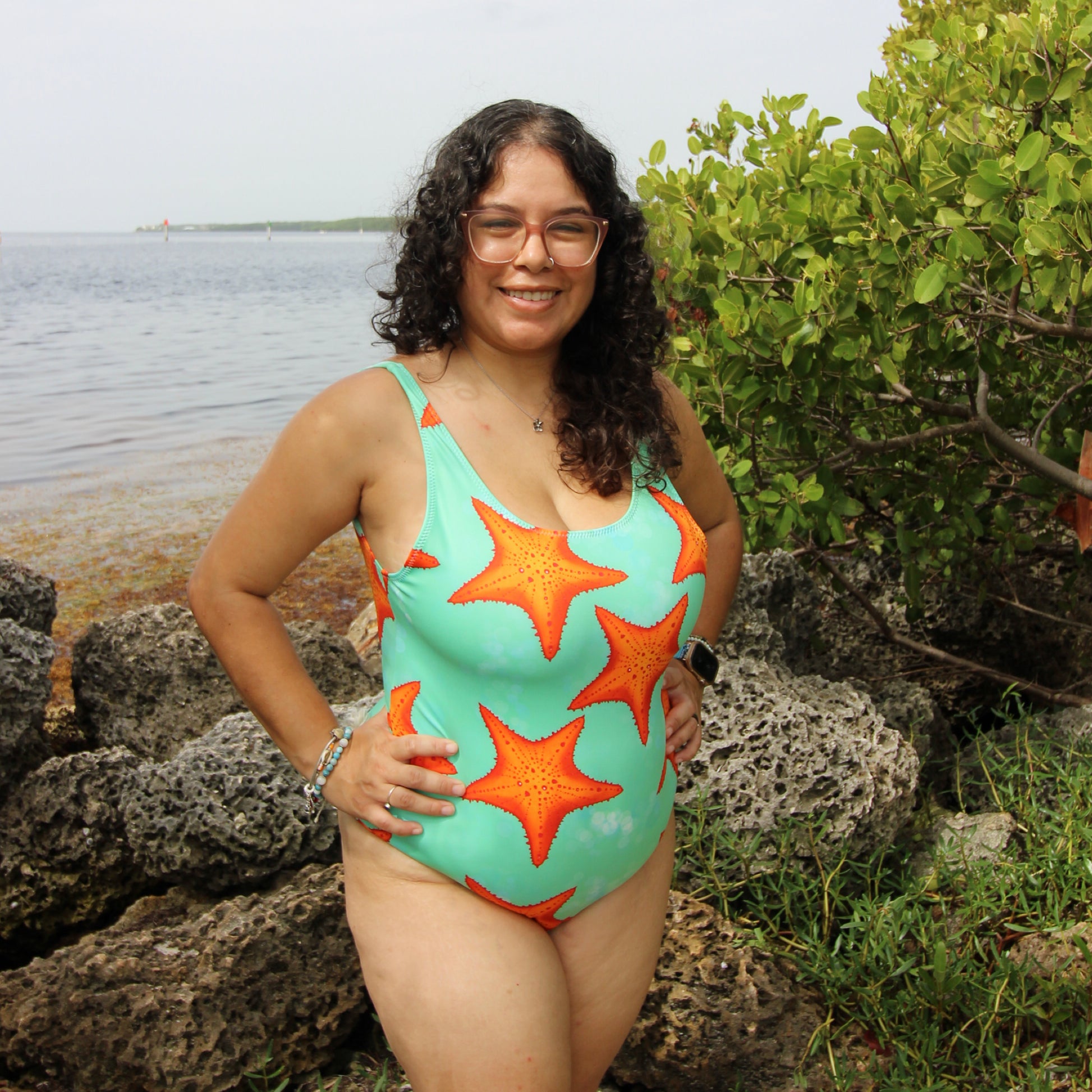 woman wearing a green and orange one piece starfish print swimsuit 