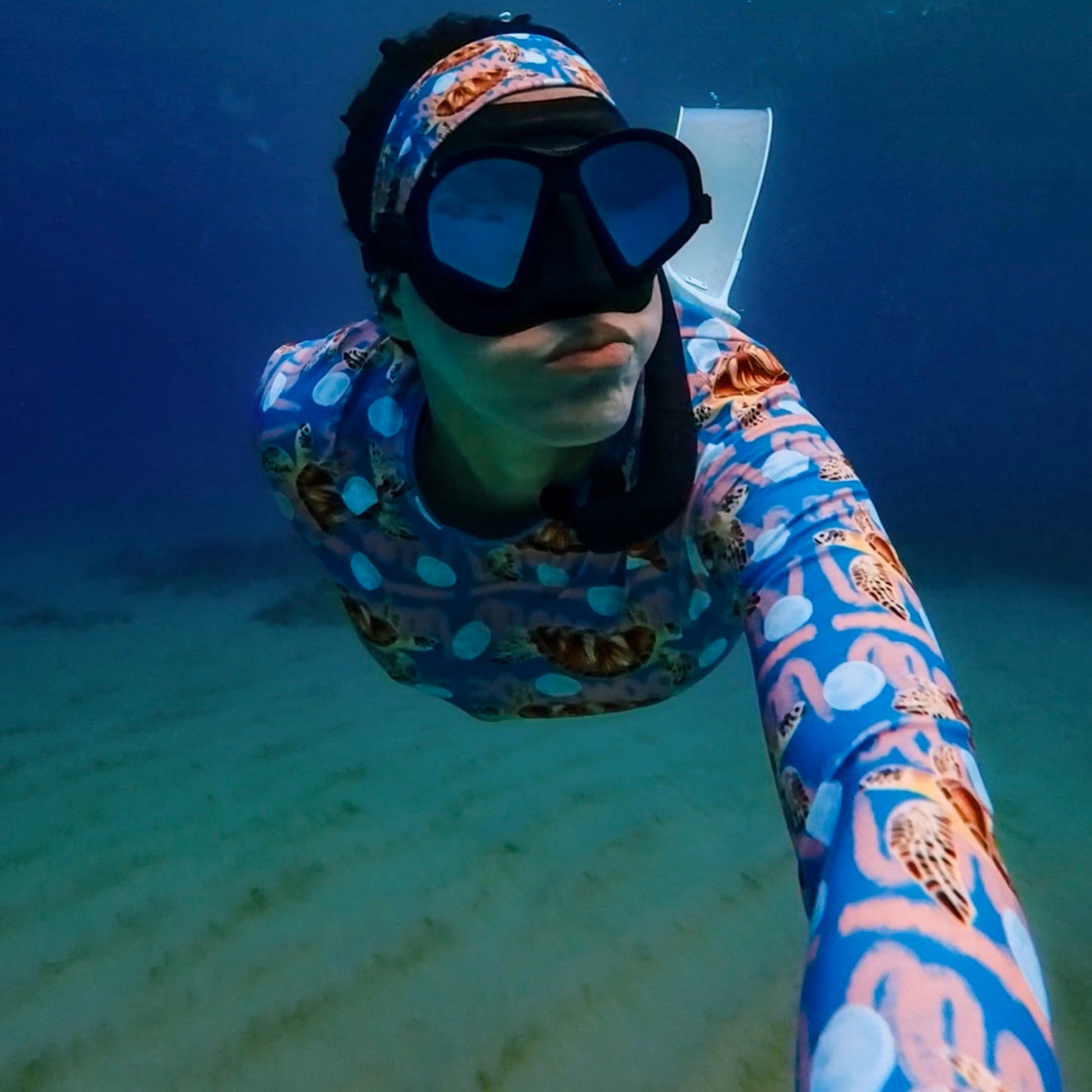 Angeline wearing the Royal blue and peachy background with sea turtles and moon jellyfish Eco dive headband