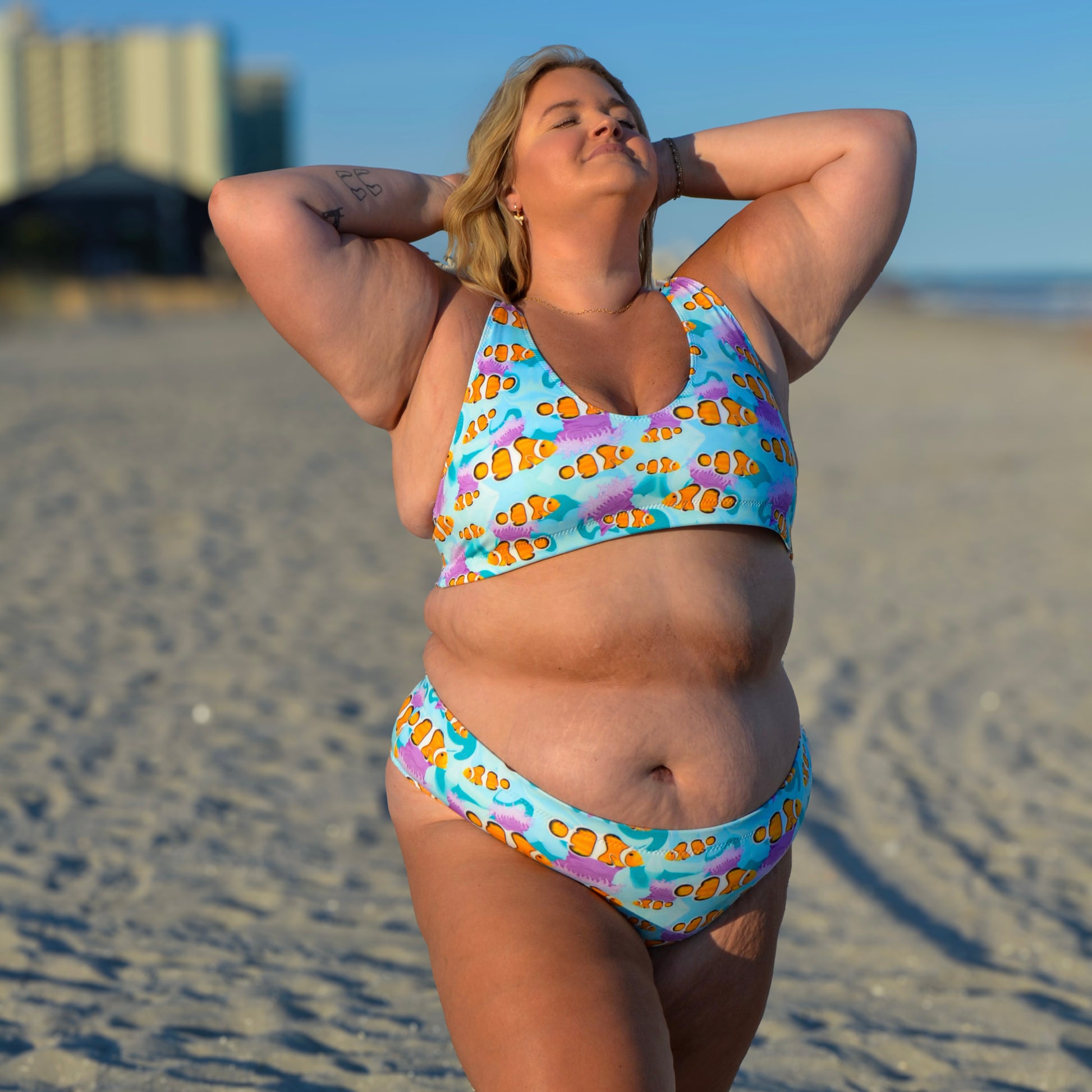 Woman standing on the beach wearing a blue, pink and orange clownfish bikini