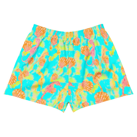 Pink and orange seahorses with sunrise seashells. Light aqua blue and yellow background with a neon yellow band. Eco unisex shorts 