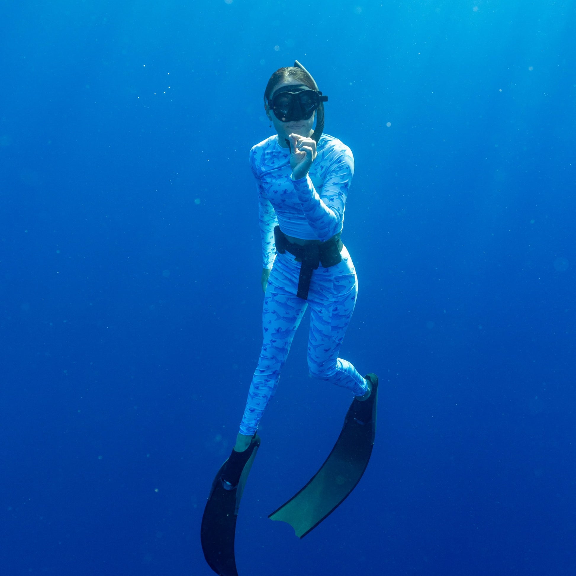 Baby blue waves and Sky Blue Tiger sharks swim around royal blue tiger shark teeth on our Tiger Beach Blues Recycled dive leggings with pockets 