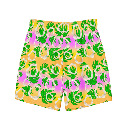 A warm golden yellow and pinky lilac sunset ombré background with megalodon jaws and monstera leaves on our Meg Monstera Recycled Swim Trunks 