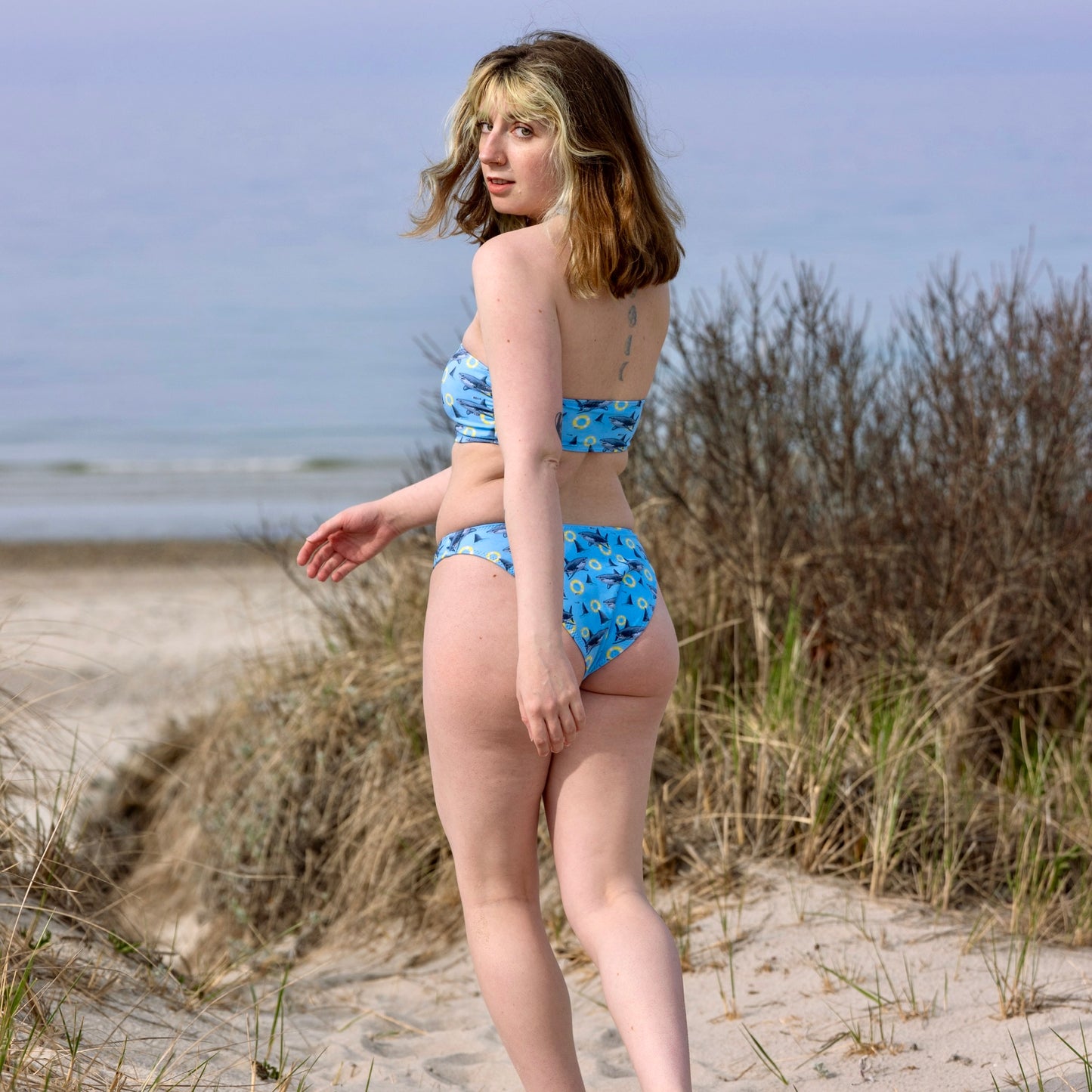 woman on the beach wearing blue bikini with great white sharks 