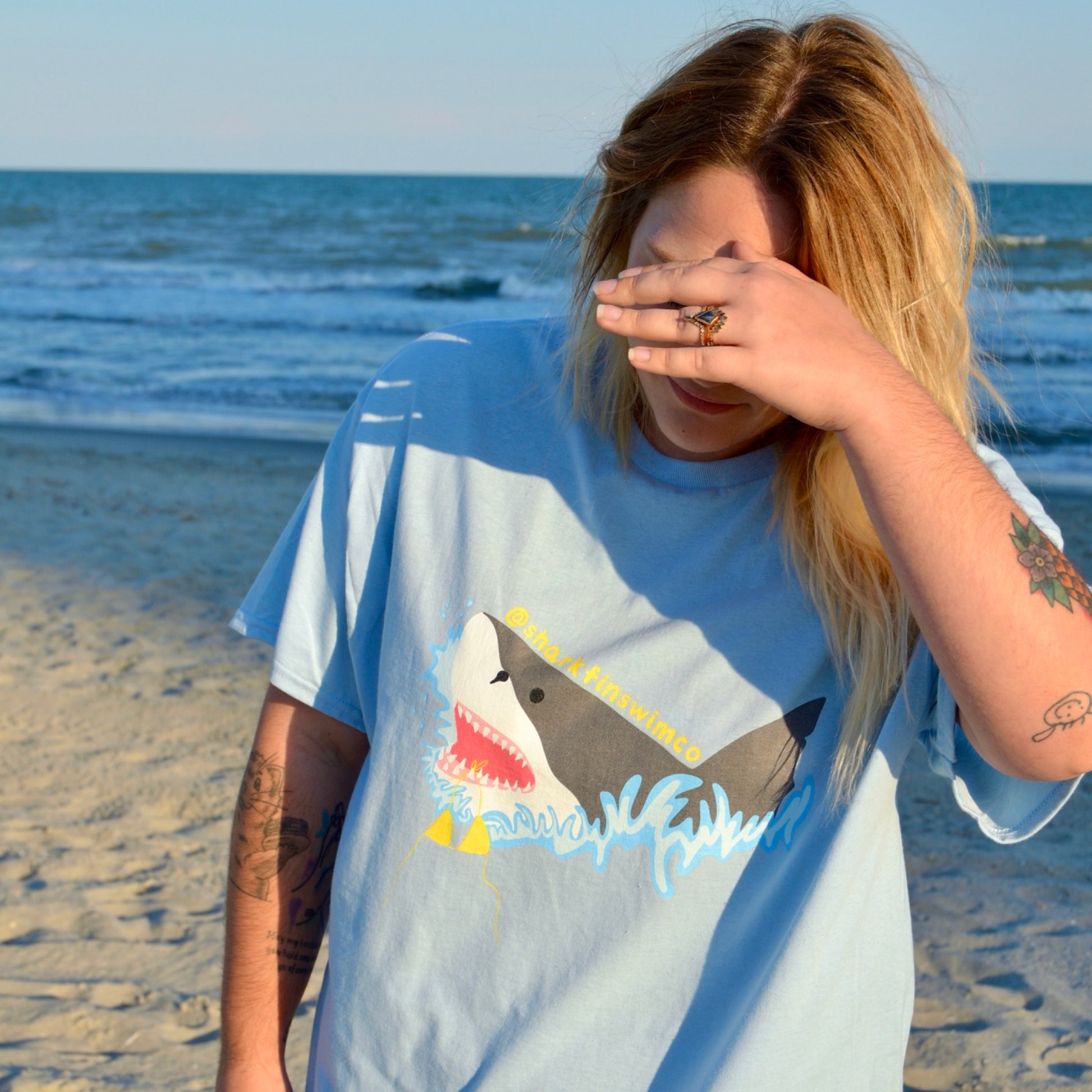 Eco-friendly t shirt with a great white shark and bikini coming out of the ocean 