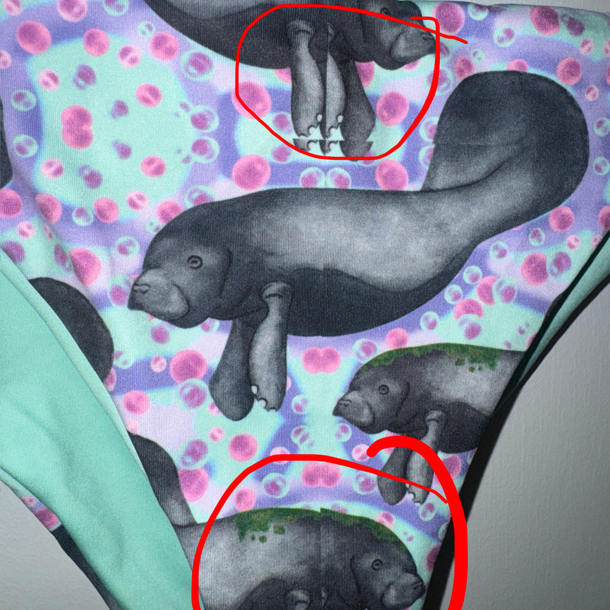 Manatees with purple, mint and pink background string bikini bottoms With red areas circled 