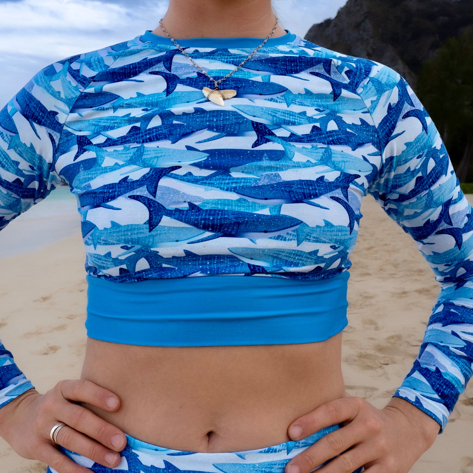 Jamie wearing the sour gummy whale shark rashguard on the beach 