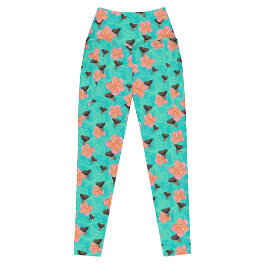 A teal and mint swirly background with Bull shark teeth and pinky orange plumeria flowers on our Shark Tooth Paradise Recycled Dive Leggings with pockets 