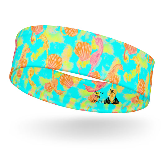 Pink and orange seahorses with sunrise seashells. Light aqua blue and yellow background with a neon yellow band. Eco dive leggings 