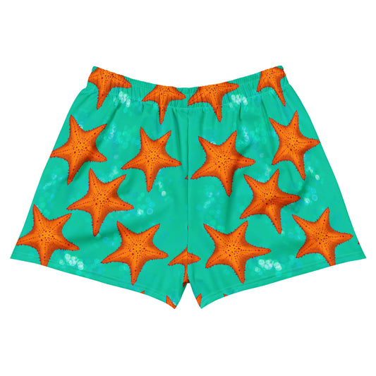 Orange starfish on a greenish teal background swim shorts