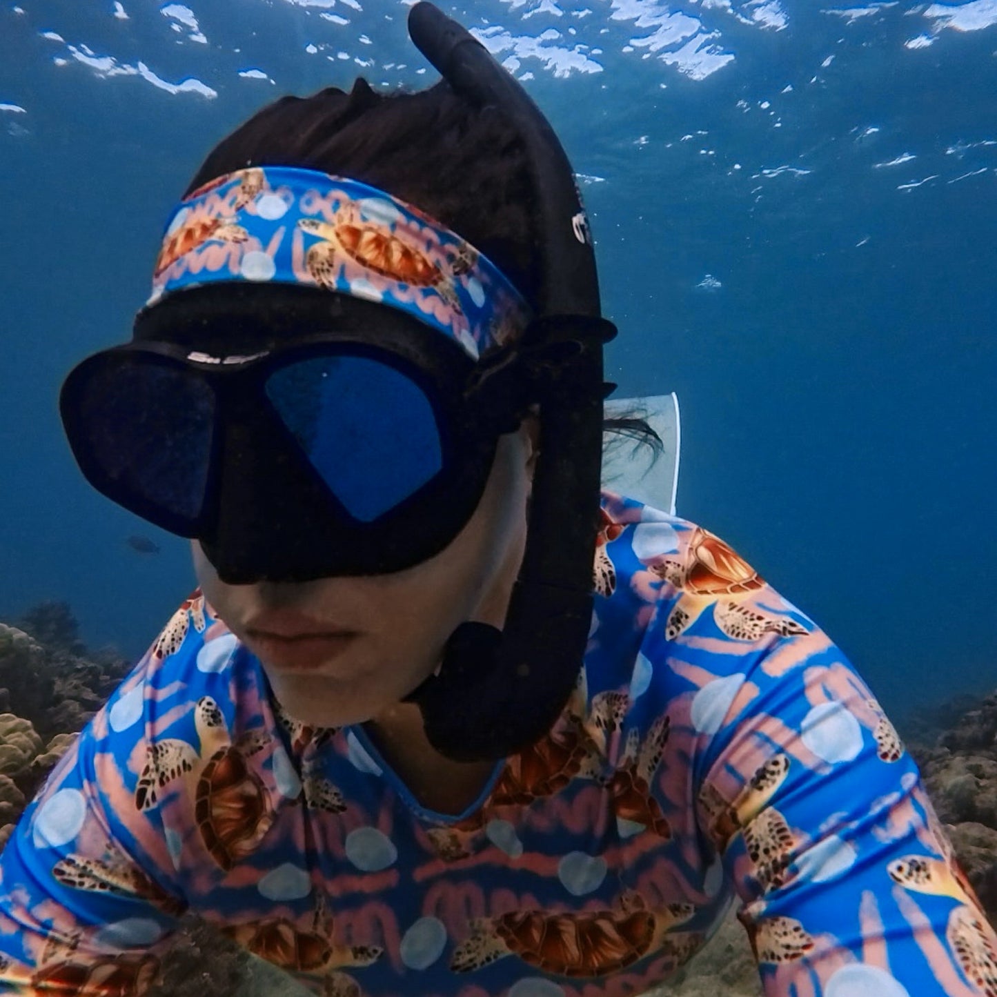 Angeline wearing the Royal blue and peachy background with sea turtles and moon jellyfish Eco dive headband