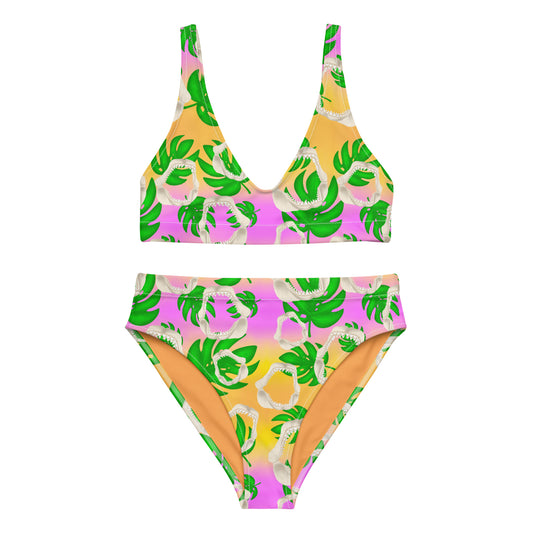 A warm golden yellow and pinky lilac sunset ombré background with megalodon jaws and monstera leaves on our Meg Monstera Recycled high waisted bikini 