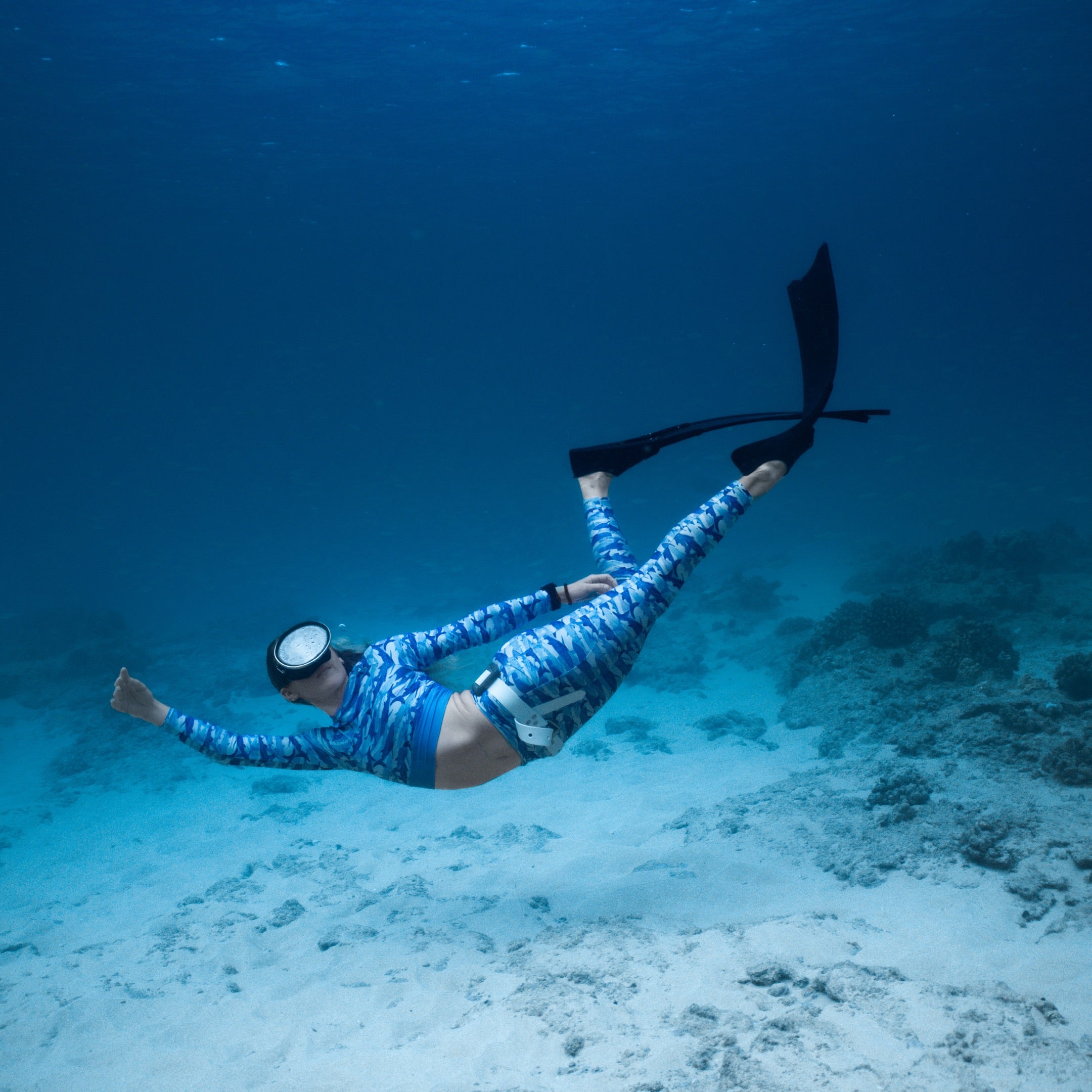 Jamie wearing the sour gummy whale shark rashguard and leggings underwater free diving 